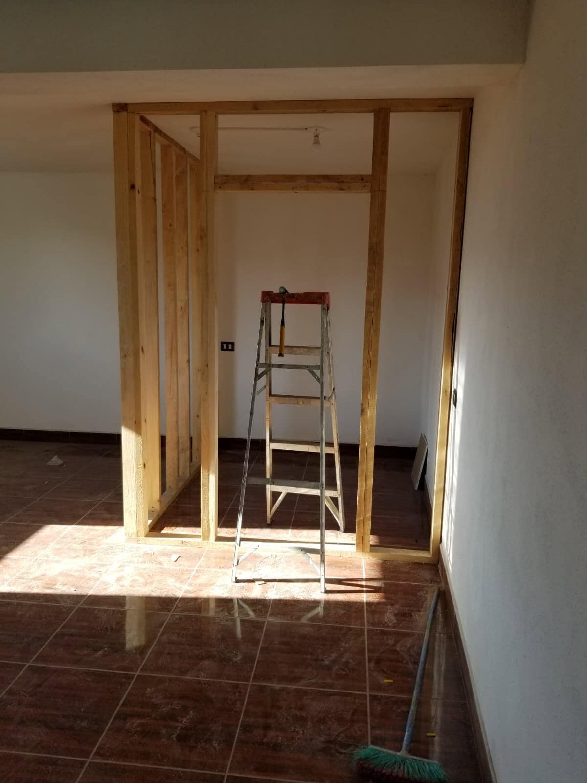 Carpentry Construction of a new room with wooden framing and ladder inside a house.