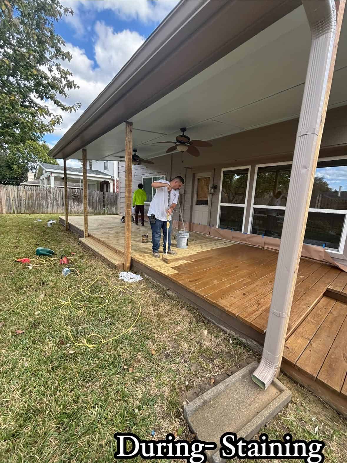 Gomez Painting About Workers staining and sealing a wooden porch on a residential home.